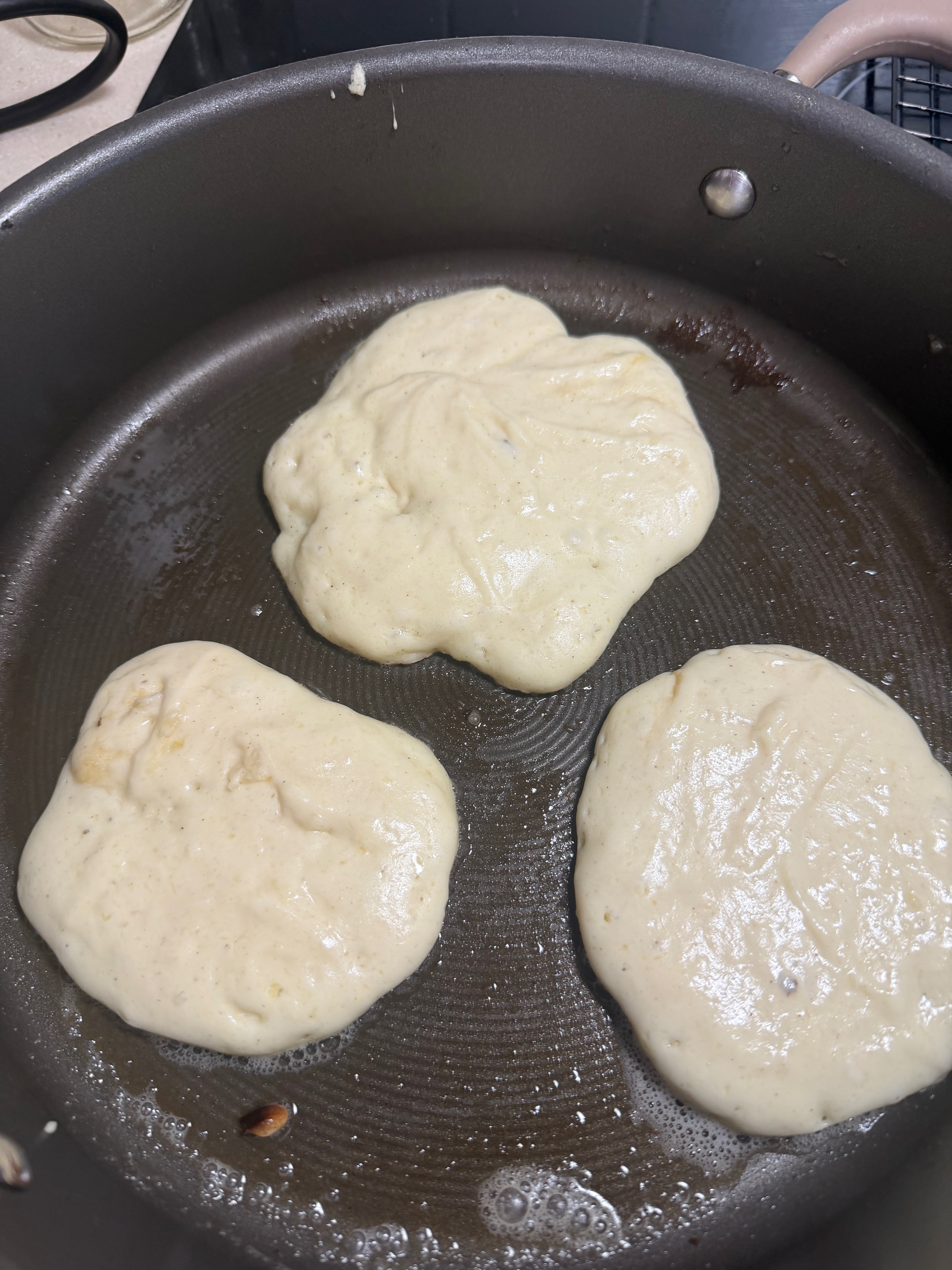 Pancakes cooking in the pan before their first flip